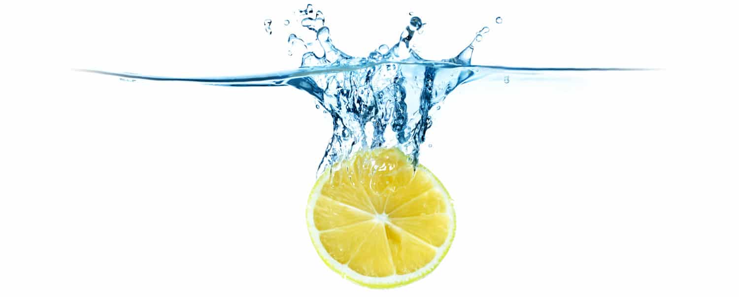 Lemon dropping into purified water