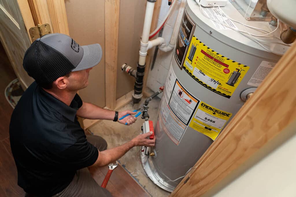 Georg from Blue Planet Plumbing, working on a water heater